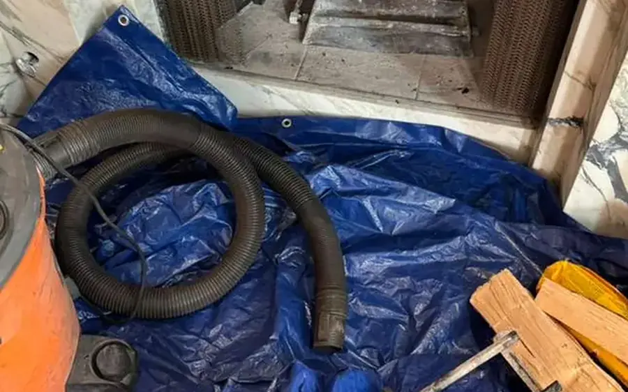Fireplace prepared for a chimney sweep with floor protection, vacuum and rods
