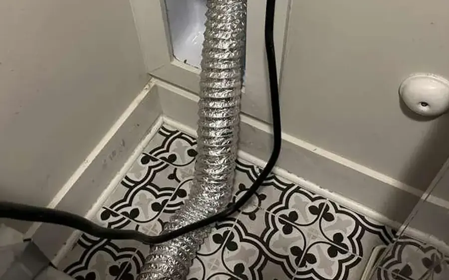 Flexible foil dryer duct behind a dryer in a laundry room